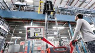 Hochhubwagen und Fahrer am Regal mit Ansicht des Load Management Advanced Displays Hochhubwagen und Fahrer am Regal mit Ansicht des Load Management Advanced Displays