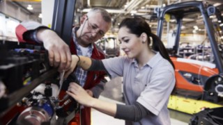 Mitarbeiter mit Auszubildender in der Produktion Mitarbeiter mit Auszubildender in der Produktion