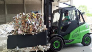 Der aufbereitete Linde H45D in Firmenfarbe der GRAU Recycling GmbH ist mit der Recyclingklammer perfekt für den Transport des Altpapiers geeignet